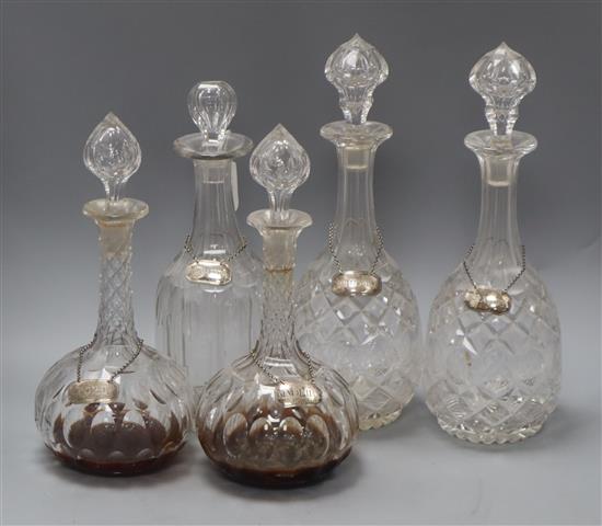 A pair of Victorian cut glass decanters, with silver labels and three other decanters with labels, Hollands, Port,